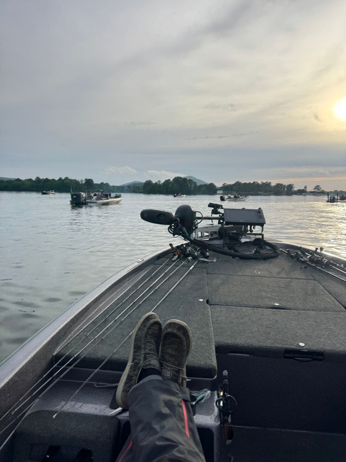 Bass boats holding on calm water at first light before tournament takeoff