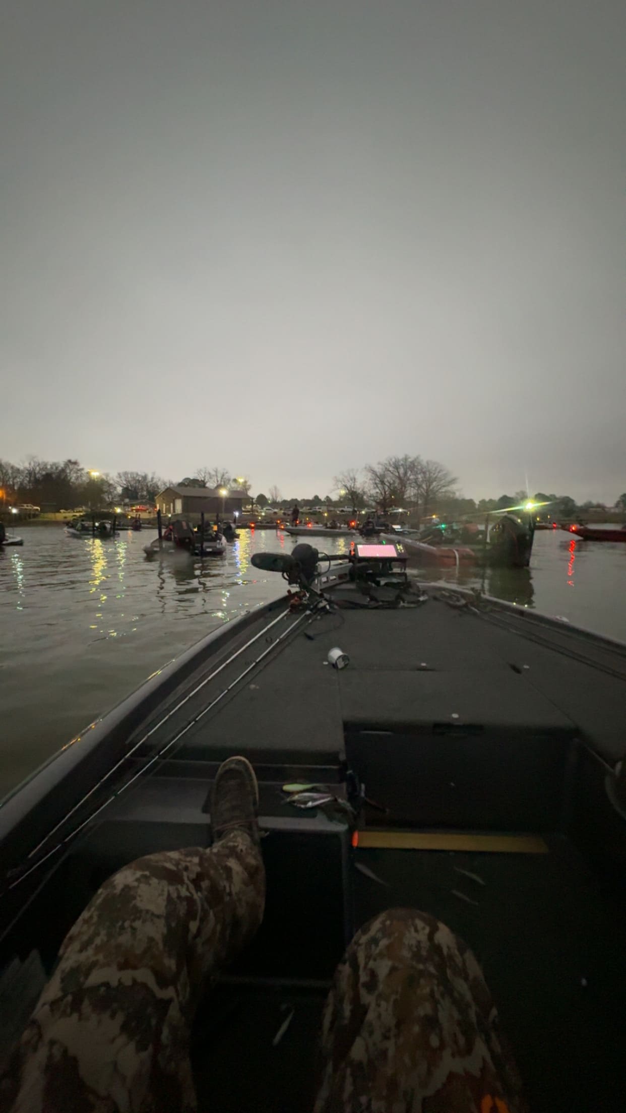 Bass boats idling at the ramp with navigation lights on, waiting on safe light before a tournament launch